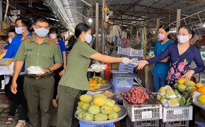 Cán bộ chiến sĩ phát khẩu trang cho người dân và tiểu thương.