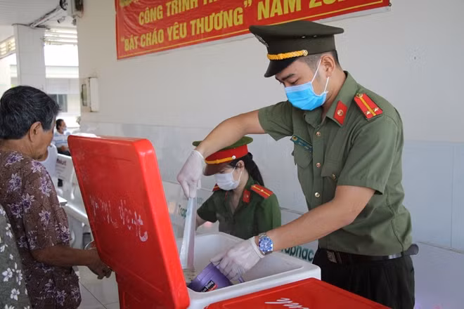 Theo thứ tự những phần cháo nóng hổi được cho vào bát nhựa, cặp lồng, trao cho người dân.