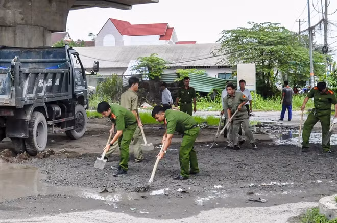 Cán bộ chiến sĩ Công an phường Hưng Lợi dặm vá đường, đảm bảo an toàn cho người dân.