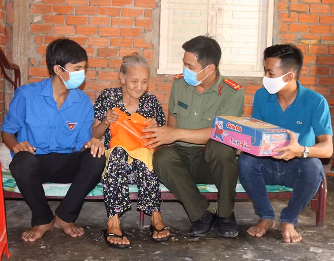 Cán bộ Đoàn, Hội Công an tỉnh và Thành đoàn Trà Vinh tặng quà người dân.