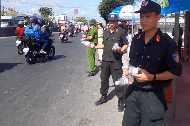 Đoàn viên thanh niên Công an tỉnh Vĩnh Long tham gia phát nước suối miễn phí cho người dân.