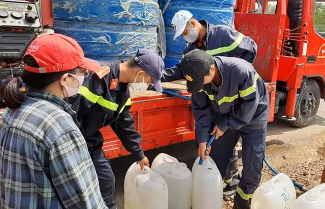 Cán bộ chiến sĩ bơm nước vào can cho người dân.