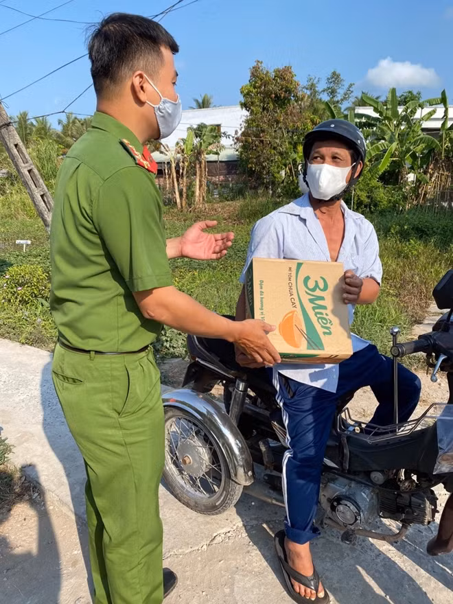 Cán bộ chiến sĩ Phòng Tham mưu tặng quà cho người bán vé số.