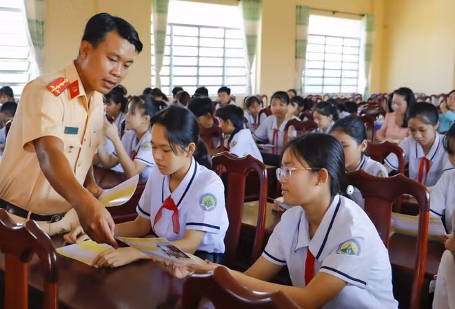 CSGT Cần Thơ phát tờ rơi, tuyên truyền Luật giao thông cho các em học sinh.