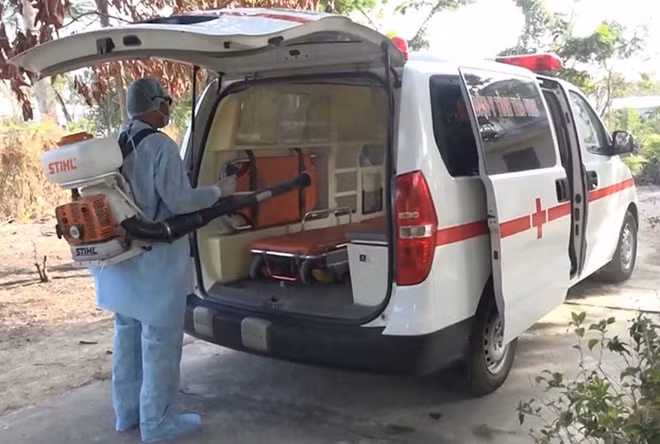 Nhân viên y tế phun thuốc khử trùng khu cách ly và phương tiện ra vào.