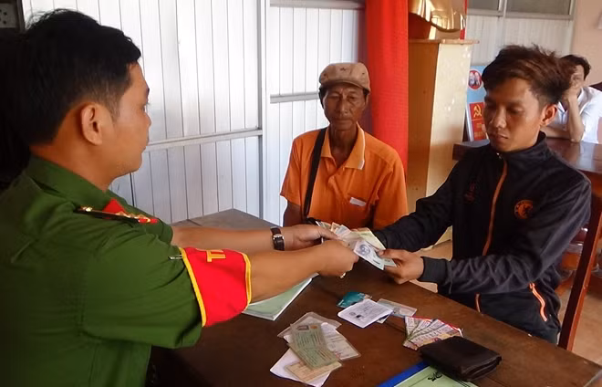 Ông Hiệp (áo vàng) tại buổi trao trả tài sản cho người đánh rơi.