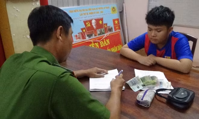Em Phạm Minh Huân, mang ví tiền đến nộp cho Công an phường.