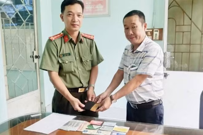 Đại úy Vũ Ngọc Hùng trao trả lại ví tiền cho người đánh rơi.