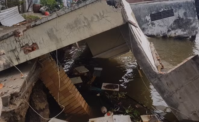 Căn nhà kiên cố bị kéo sụp xuống nước.