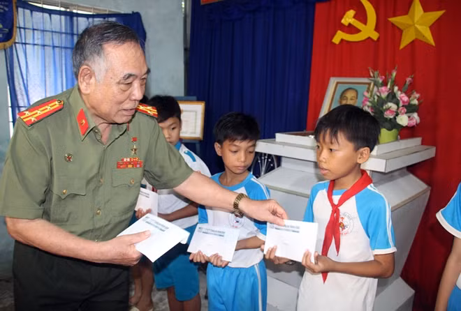 Đại tá Trần Phương Thế trao quà cho các em học sinh