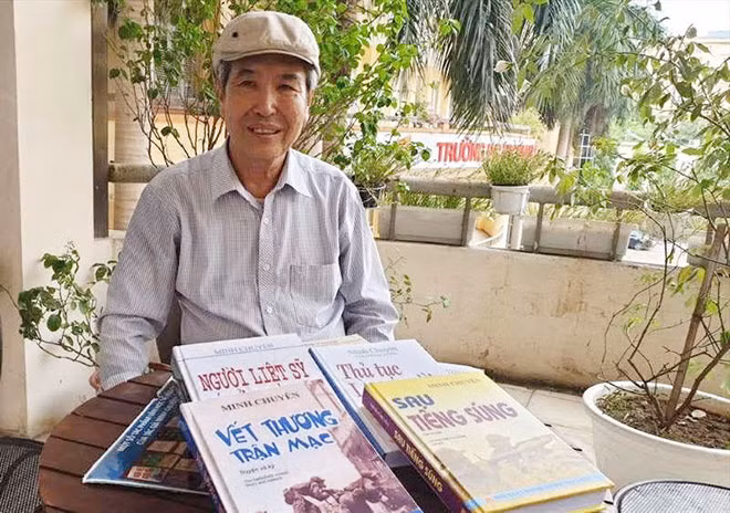 Nhà văn Minh Chuyên trước một số tác phẩm của mình.