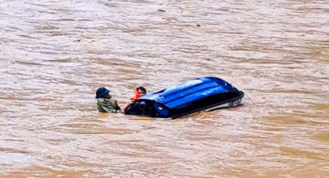 Mô tô nước bị nước lũ xô lật.