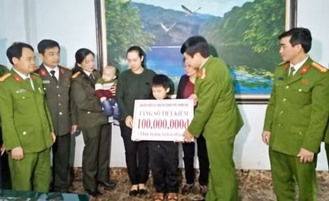Đại tá Khương Duy Oanh và tập thể lãnh đạo Công an TP Thanh Hóa trao sổ tiết kiệm cho gia đình chị Hồ Thị Ánh Tuyết.