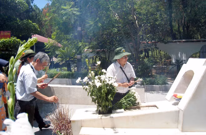 Nhà văn Đào Thắng (phải) bên mộ 10 cô gái ở ngã ba Đồng Lộc.