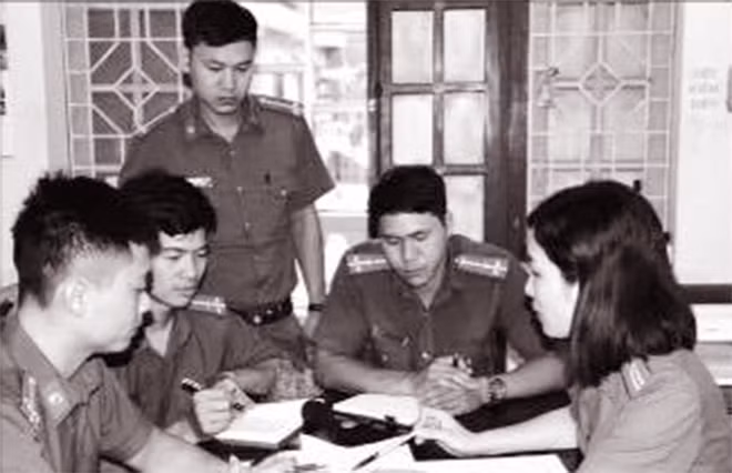 Thiếu tá Hoàng Phương Thảo đang trao đổi nghiệp vụ với các đồng nghiệp.