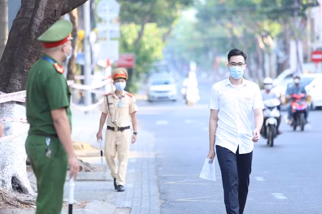 Lực lượng công an tham gia bảo vệ bên ngoài cổng trường thi cũng đeo khẩu trang y tế, găng tay và mũ kính chống bắn giọt để đảm bảo an toàn phòng chống dịch bệnh.