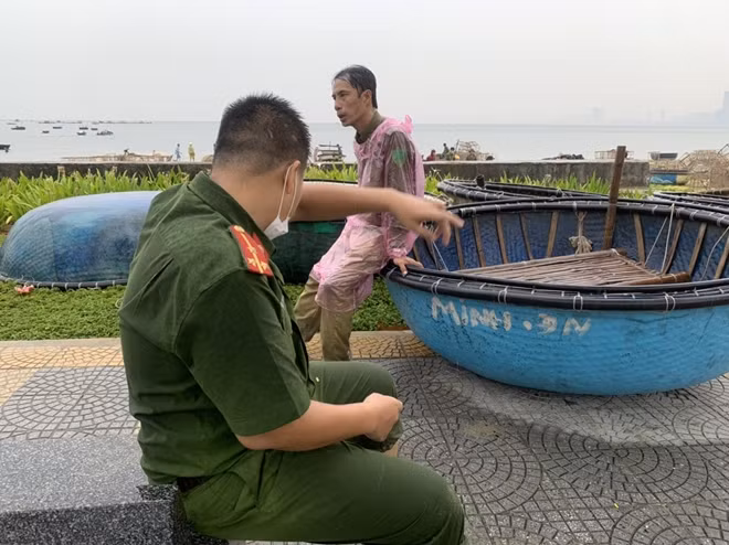 Phút nghỉ ngơi lấy lại sức để tiếp tục nhiệm vụ giúp ngư dân kéo tàu thuyền vào bờ của một chiến sĩ Công an cùng lực lượng dân quan phường Thọ Quang, quận Sơn Trà.