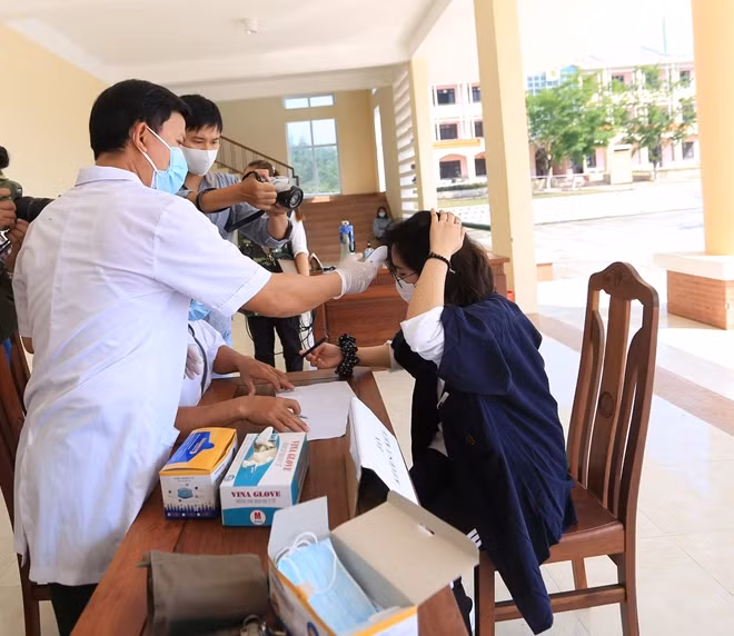 Các công dân Việt Nam được kiểm tra thân nhiệt và sức khỏe lần cuối cùng trước khi rời khu cách ly Đồng Nghệ (Đà Nẵng) trở về với gia đình, người thân.