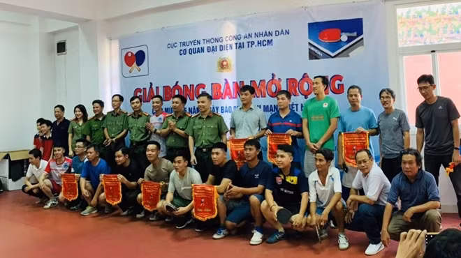 Thượng tá Dương Văn Toàn - Trưởng CQĐD Cục Truyền thông CAND tại TP Hồ Chí Minh trao cờ cho các VĐV thi đấu bóng bàn