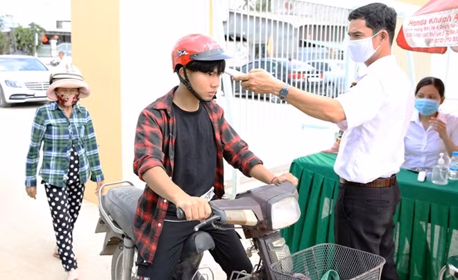 Người dân được đo thân nhiệt và phát khẩu trang