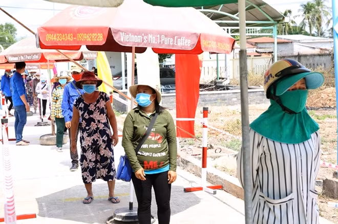 Người dân xếp hàng, giữ khoảng cách để vào nhận gạo