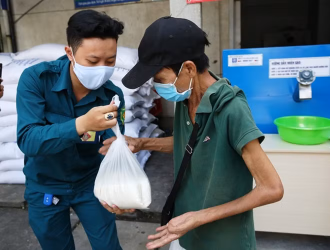 Giúp đỡ những người khó khăn, tàn tật khi đến lấy gạo