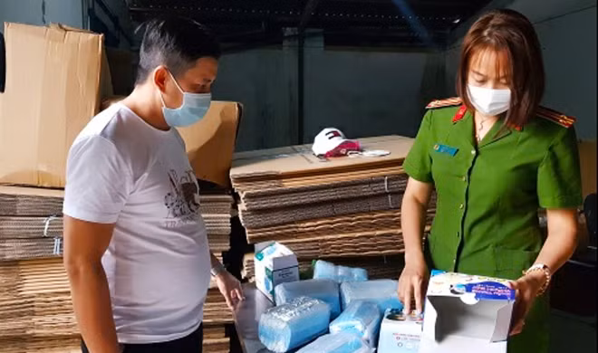 Công an đang làm việc với chủ số lượng lớn khẩu trang y tế trên
