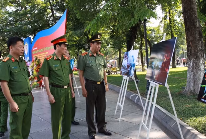 Trung tướng Lê Văn Đệ và Thiếu tướng Đoàn Việt Mạnh, Cục trưởng Cục Cảnh sát PCCC và CNCH xem các tác phẩm ảnh trưng bày tại triển lãm