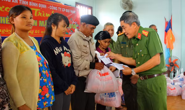 Đại tá Trần Thái Học – Trưởng Công an huyện Vân Canh và Thượng tá Võ Tấn Tài – Phó trưởng Phòng công tác chính trị Công an Bình Định trao quà tết của Báo CAND cho người dân.