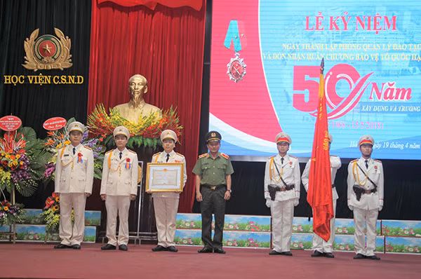 Thiếu tướng Nguyễn Quang Chữ trao Huân chương Bảo vệ Tổ quốc hạng nhì cho Phòng Quản lý đào tạo.