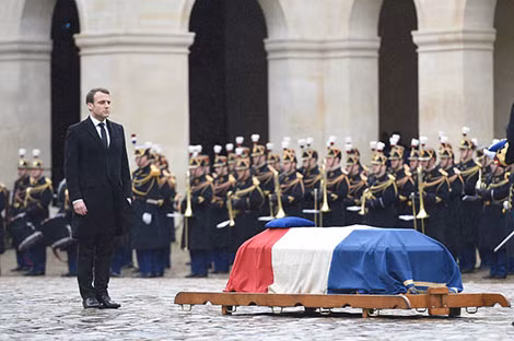 Tổng thống Emmanuel Macron đứng nghiêm trang khi bài quốc ca Pháp vang lên trong lễ tang Đại tá Arnaud Beltrame. Ảnh: AP.