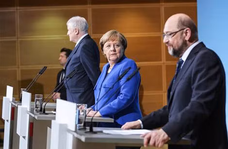 Bà Angela Merkel và lãnh đạo đảng SPD Martin Schulz (bên phải) tại cuộc họp báo chung ngày 12-1.