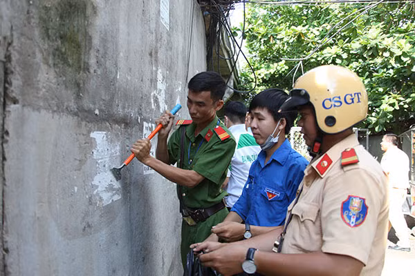 Công an quận Cái Răng (TP Cần Thơ) ra quân tẩy xóa quảng cáo cho vay tiền trên địa bàn.