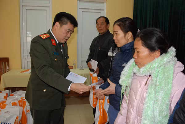 Thượng tá Lương Hoàng Vịnh, Phó trưởng Phòng Công tác chính trị - Công an tỉnh Tuyên Quang trao quà Tết tới đồng bào nghèo xã Bình Yên.