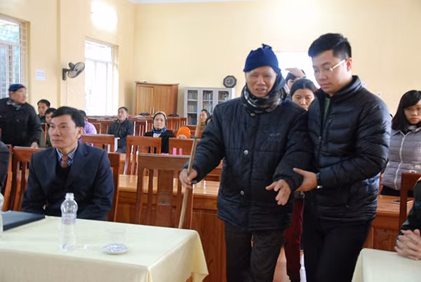 Thành viên đoàn công tác dìu bà con lên nhận quà.