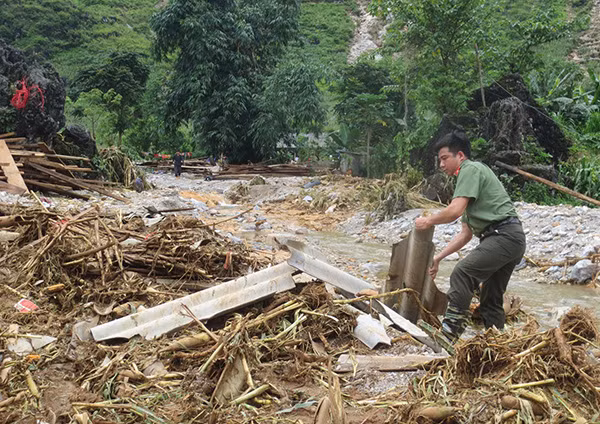 Cán bộ chiến sĩ Công an huyện Quản Bạ giúp xuống cơ sở giúp dân khắc phục hậu quả sau lũ dữ.