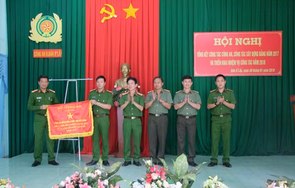 Đại tá Nguyễn Văn Hùng – Phó Giám đốc Công an tỉnh Đắk Nông trao cờ thi đua của Bộ Công an tặng tập thể Công an huyện Đắk Rlấp.