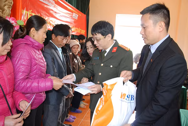 Phó Tổng Biên tập Phạm Quang Khải và ông Phạm Tuân – Phó Chủ tịch Công đoàn SHB chi nhánh tỉnh Tuyên Quang tặng quà Tết tới đồng bào nghèo xã Tú Thịnh.