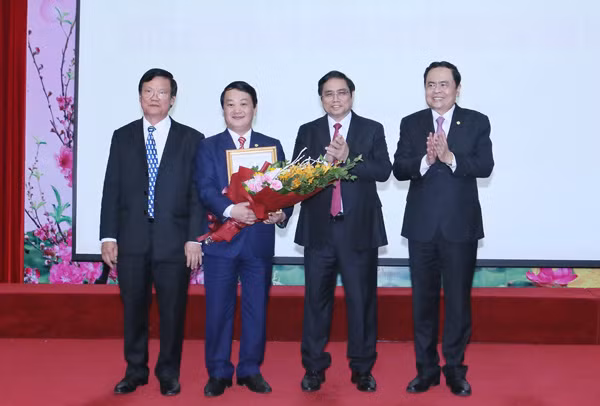 Trưởng Ban Tổ chức Trung ương Phạm Minh Chính và Bí thư Đảng Đoàn, Chủ tịch UBTƯ MTTQ Việt Nam trao hoa chúc mừng đồng chí Hầu A Lềnh.