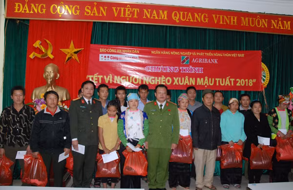 Đại diện Báo CAND cùng lãnh đạo Công an huyện Tuần Giáo trao quà Tết tới đồng bào nghèo xã Pú Nhung.