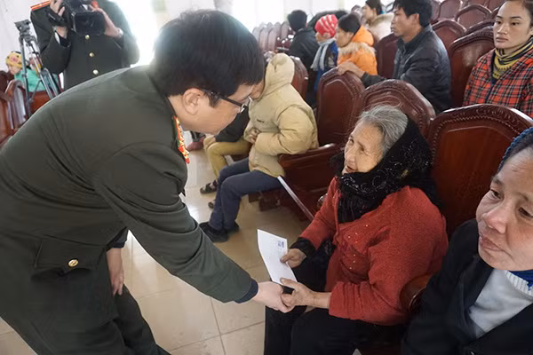 Đại tá Nguyễn Anh Tuấn xuống tận nơi để trao quà cho một bà cụ cao tuổi.