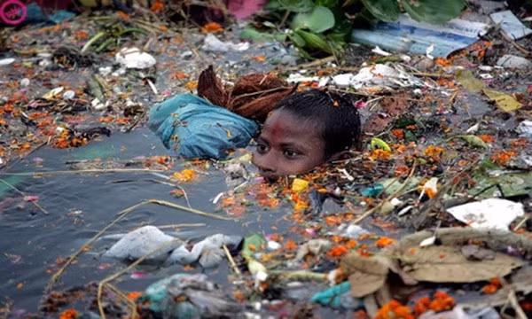 Bức ảnh này chụp một cậu bé đang cố gắng bơi qua sông Yamuna (Ấn Độ) với đầy rác rưởi.