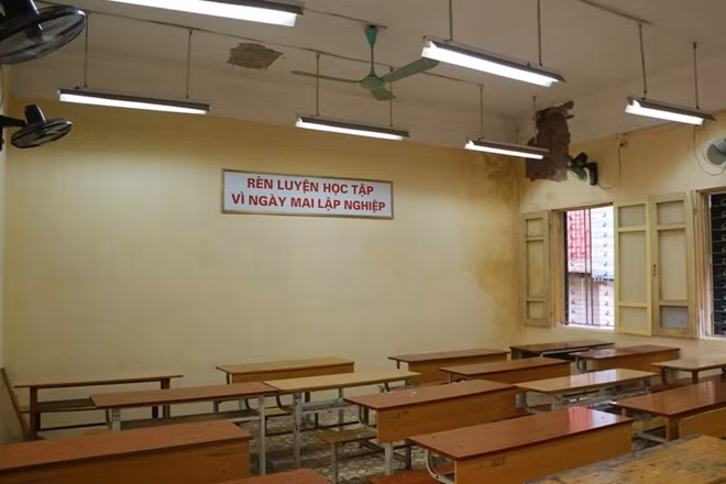 Bên trong một lớp học bị buộc phải niêm phong với một bên tường loang lỗ do bong vữa.