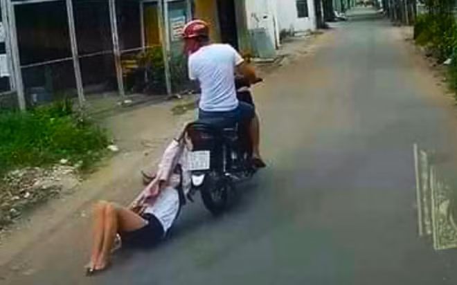 Hình ảnh đối tượng Trần Gia Đức kéo lê cô gái sau khi cướp điện thoại.
