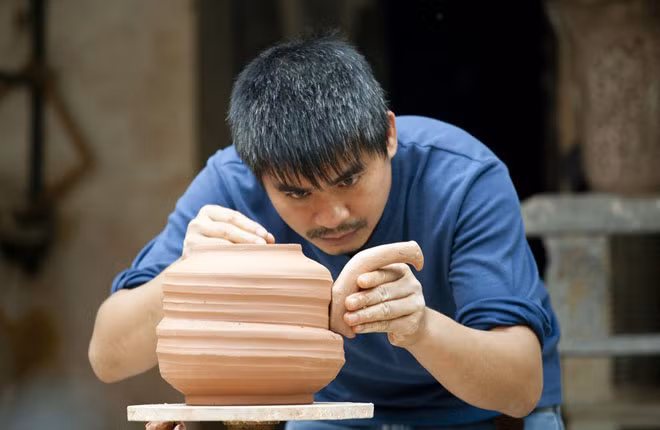Họa sĩ Nguyễn Hồng Tân miệt mài bên sản phẩm của mình. Họa sĩ Nguyễn Hồng Tân miệt mài bên sản phẩm của mình.