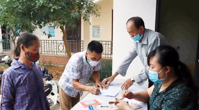 Chi trả tiền hỗ trợ cho hộ nghèo. Ảnh minh họa: TTXVN.