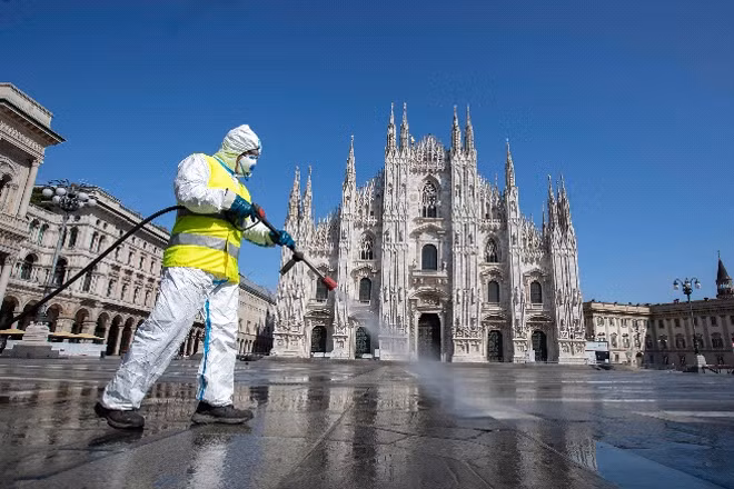 Một nhân viên y tế phun thuốc khử trùng tại quảng trường Duomo, Milan, Italia, tâm dịch của châu Âu. Ảnh: AP.