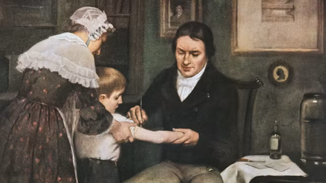 Tranh vẽ minh họa cảnh bác sĩ Edward Jenner tiêm chất lỏng lấy từ mụn đậu mùa cho cậu bé Phillip. Tranh vẽ minh họa cảnh bác sĩ Edward Jenner tiêm chất lỏng lấy từ mụn đậu mùa cho cậu bé Phillip.