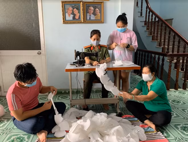 Các thành viên trong gia đình Trung tá Đoàn Thu Hà hăng say, tình nguyện may khẩu trang vì cộng đồng.