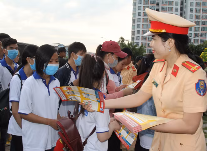 Nữ cán bộ Phòng CSGT đường bộ Công an TP Cần Thơ phát tờ rơi tuyên truyền Luật Giao thông.
